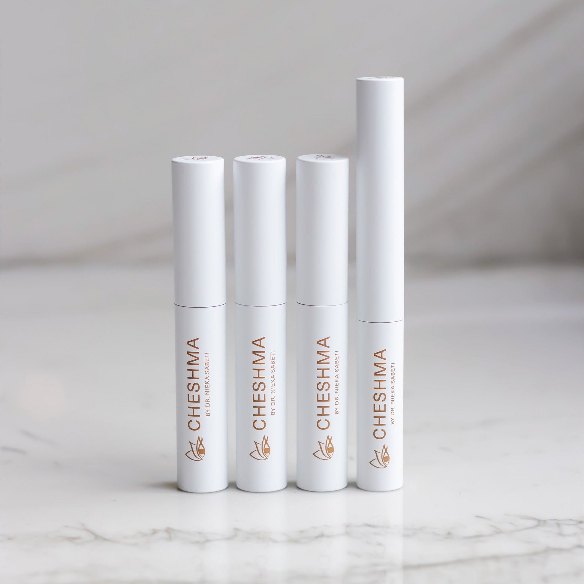 Cheshma mascara and eyeliner vials on marble countertop