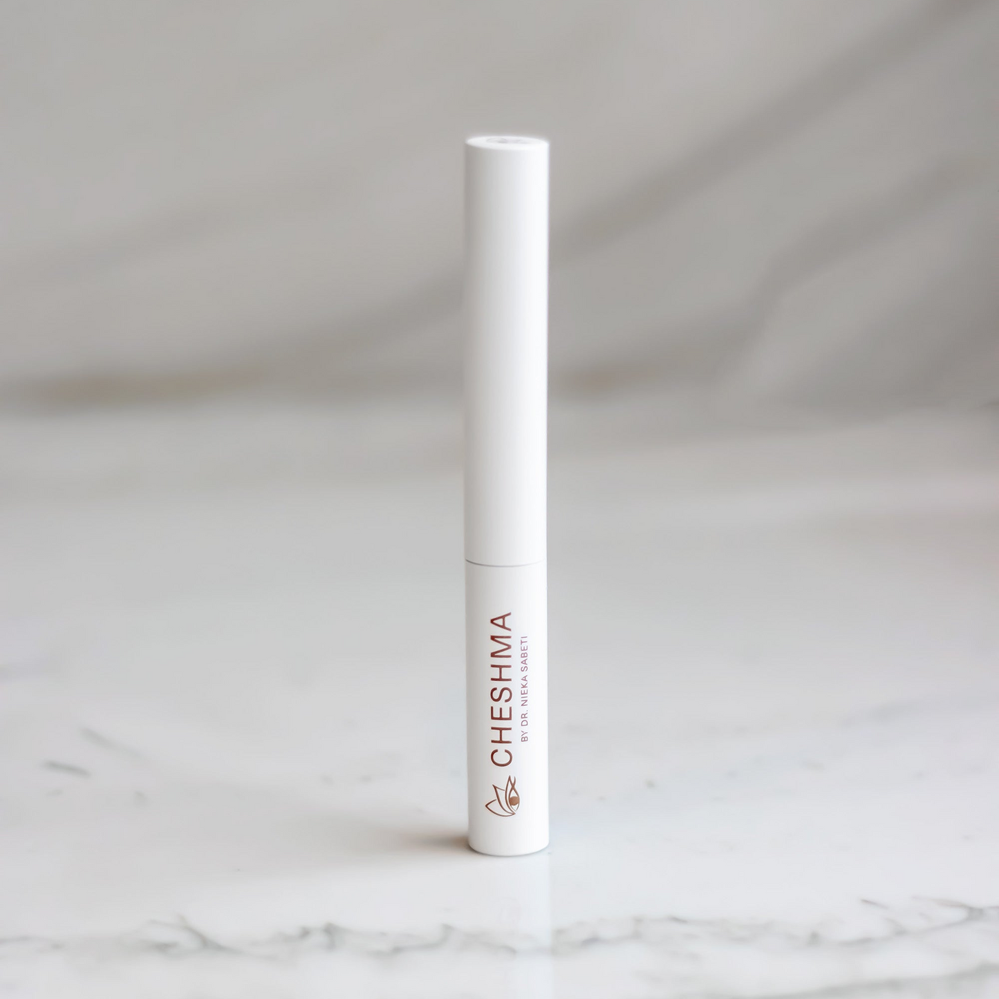 White cylindrical product with 'Cheshma' branding on a marble surface