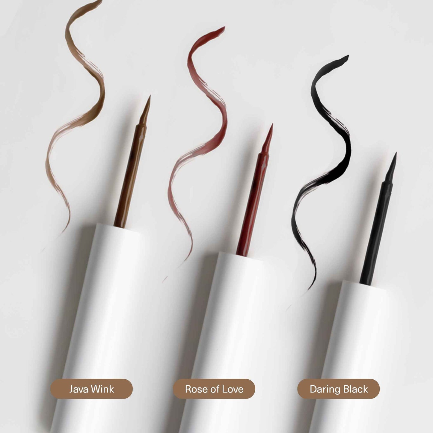 Three eyeliner pens with colored wands on a white background