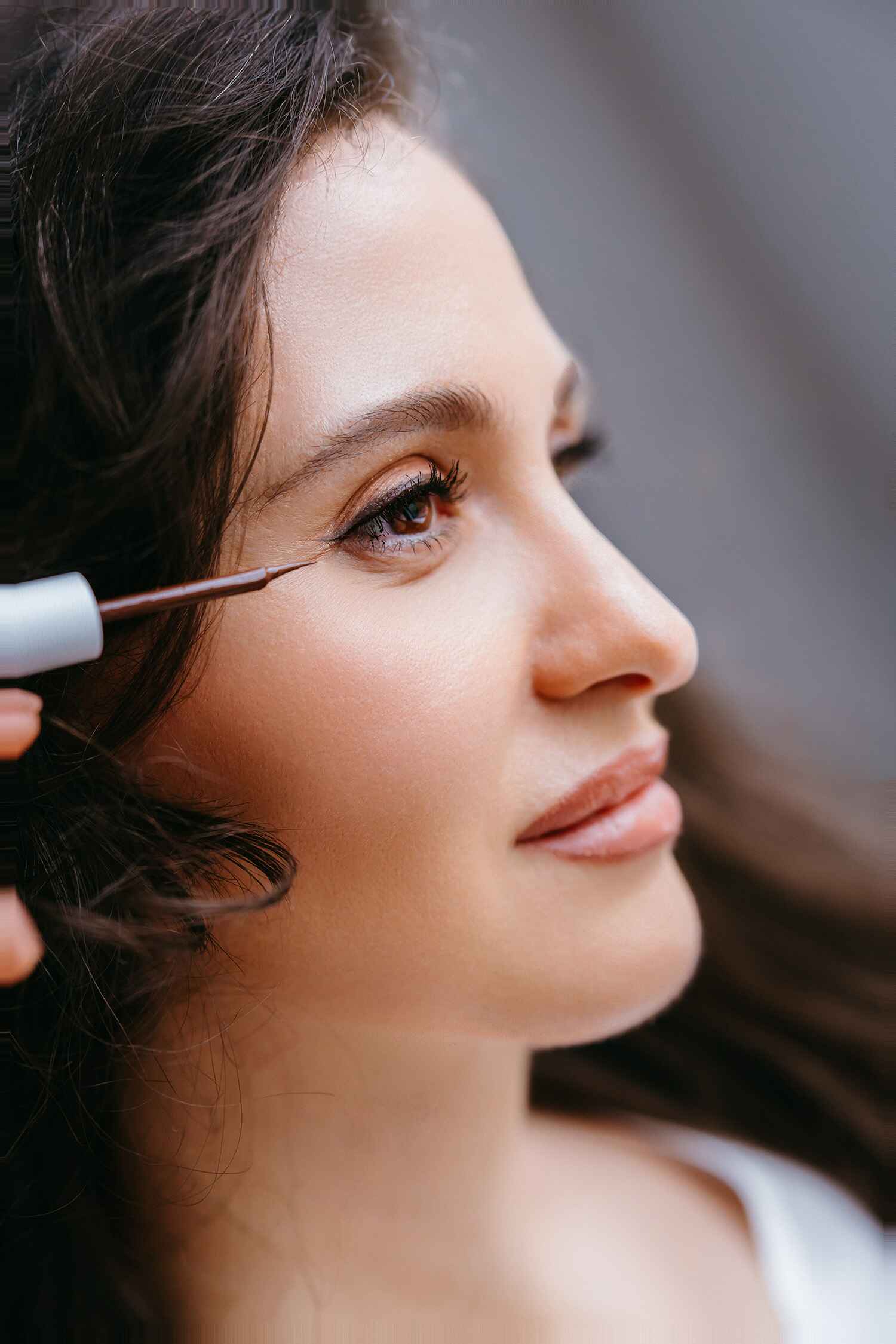 Woman applying liquid eyeliner with a brush close-up