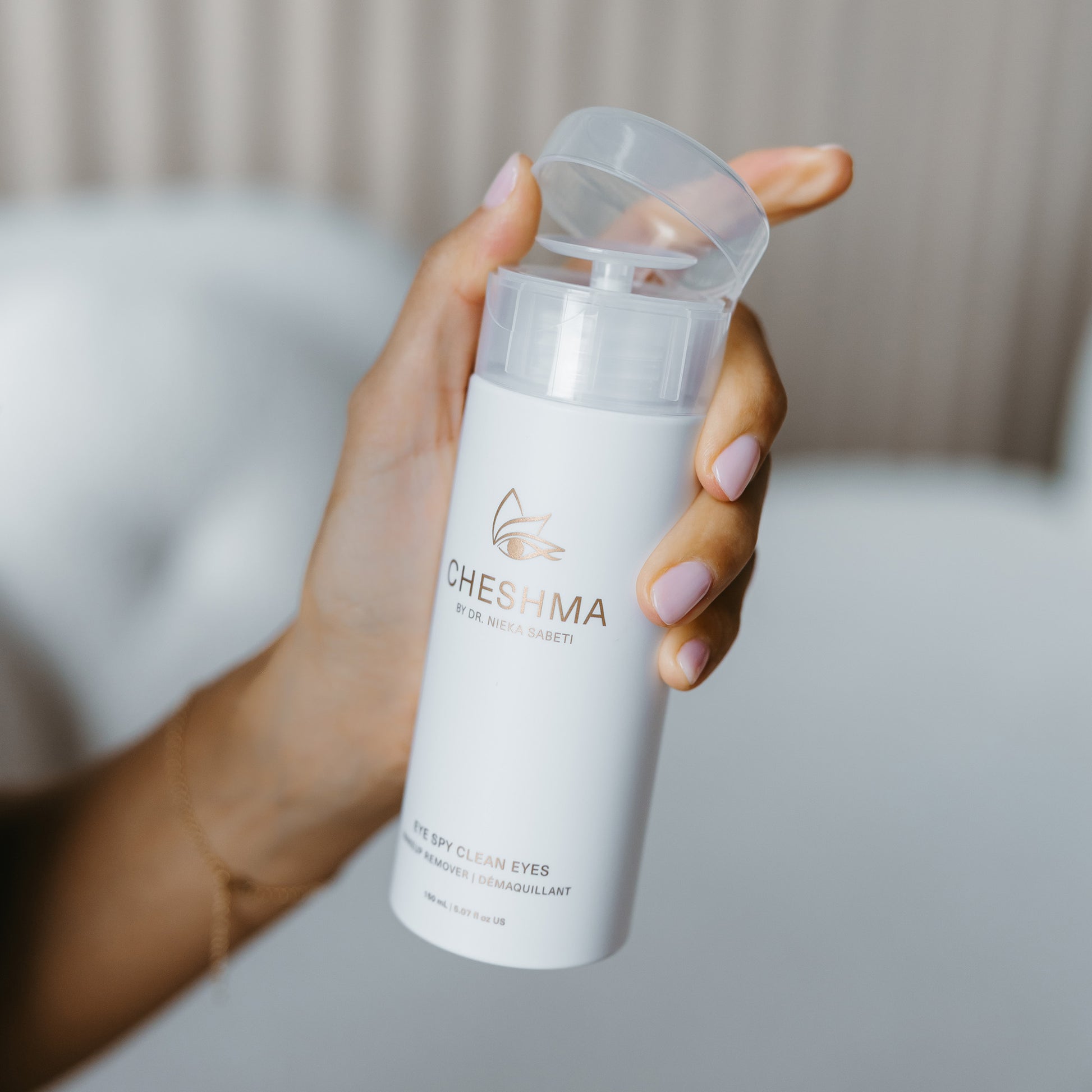 elegant hand holding Cheshma eye makeup remover while opening lid 